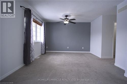 Spare room with light colored carpet, ceiling fan, and a textured ceiling - 919 Zeller Crescent, Kitchener, ON - Indoor Photo Showing Other Room
