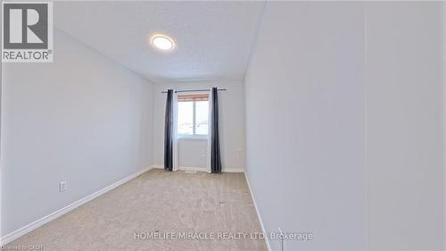Unfurnished room featuring a textured ceiling and light colored carpet - 919 Zeller Crescent, Kitchener, ON - Indoor Photo Showing Other Room