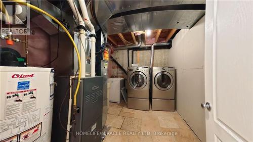 Washroom featuring water heater, light stone finish floors, and separate washer and dryer - 919 Zeller Crescent, Kitchener, ON - Indoor