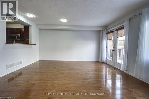 Empty room featuring a textured ceiling, french doors, dark wood-type flooring, and recessed lighting - 919 Zeller Crescent, Kitchener, ON - Indoor Photo Showing Other Room