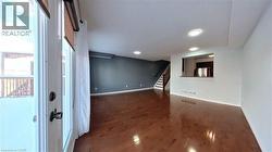 Unfurnished living room featuring stairway and dark wood finished floors - 