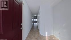 Hall featuring a textured ceiling and baseboards - 