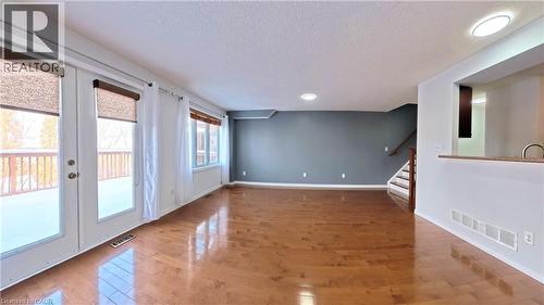 Empty room featuring wood finished floors, stairs, and a textured ceiling - 919 Zeller Crescent, Kitchener, ON - Indoor Photo Showing Other Room