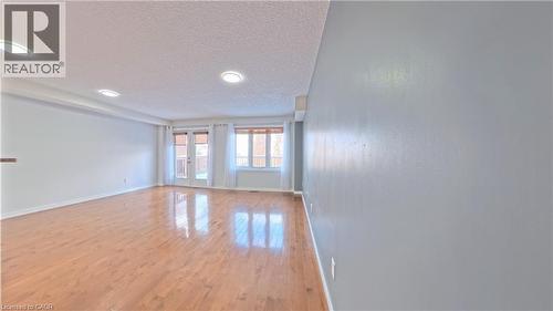 Spare room with a textured ceiling, light wood-style flooring, and french doors - 919 Zeller Crescent, Kitchener, ON - Indoor Photo Showing Other Room