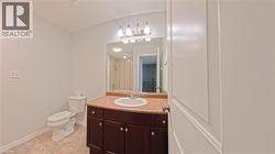 Bathroom featuring vanity, tiled shower, and light tile patterned flooring - 