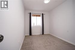 Unfurnished room featuring light colored carpet and a textured ceiling - 