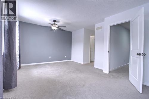 Unfurnished room with light colored carpet, a textured ceiling, and a ceiling fan - 919 Zeller Crescent, Kitchener, ON - Indoor Photo Showing Other Room
