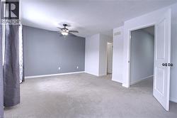 Unfurnished room with light colored carpet, a textured ceiling, and a ceiling fan - 
