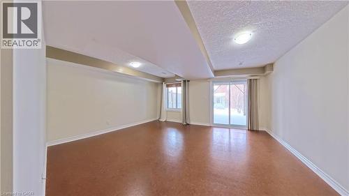 Unfurnished room featuring a textured ceiling and tile patterned floors - 919 Zeller Crescent, Kitchener, ON - Indoor Photo Showing Other Room