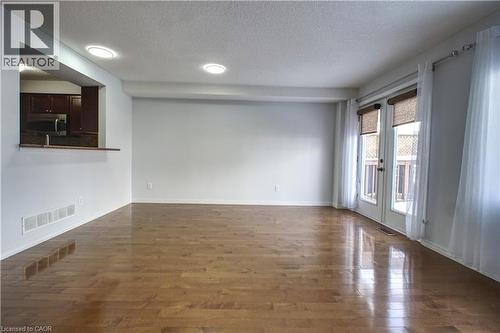 Unfurnished room with a textured ceiling, dark wood-type flooring, and french doors - 919 Zeller Crescent, Kitchener, ON - Indoor Photo Showing Other Room