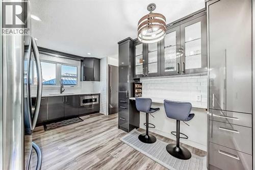 Kitchen sink overlooking backyard and new cabinets with eat-in or coffee bar - 216 Pinecrest Crescent Ne, Calgary, AB - Indoor