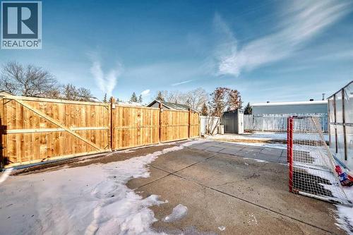 Fence has panel gate that rolls open to allow for parking - 216 Pinecrest Crescent Ne, Calgary, AB - Outdoor