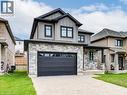View of front of home featuring board and batten siding, an attached garage, stone siding, and decorative driveway - 2527 Holbrook Drive, London, ON  - Outdoor With Facade 