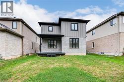 Rear view of property with board and batten siding, a yard, and brick siding - 