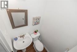 Half bathroom featuring a sink and dark wood finished floors - 