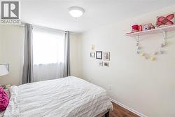 Bedroom featuring dark wood finished floors and baseboards - 