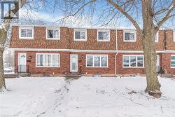 View of front of home featuring mansard roof, roof with shingles, and brick siding - 