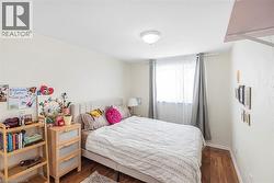 Bedroom with dark wood-style flooring and baseboards - 