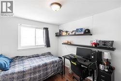 Bedroom featuring an office area and dark wood-style flooring - 