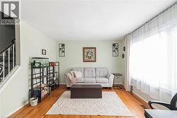 Living area with stairway and wood finished floors - 
