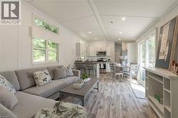 Living room with light wood-type flooring and recessed lighting - 