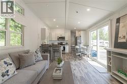 Living area featuring recessed lighting, light wood-type flooring, ornamental molding, and lofted ceiling - 