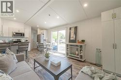 Living room featuring lofted ceiling, light wood-style floors, and recessed lighting - 