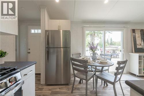 Kitchen featuring appliances with stainless steel finishes, dark countertops, and light wood-type flooring - 85 Hutchinson Beach Road Unit# B56, Huntsville, ON - Indoor