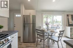 Kitchen featuring appliances with stainless steel finishes, dark countertops, and light wood-type flooring - 