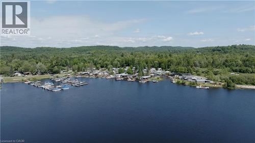 Aerial overview of property's location with a forest and a nearby body of water - 85 Hutchinson Beach Road Unit# B56, Huntsville, ON - Outdoor With Body Of Water With View