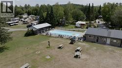 Drone / aerial view of a pool and a heavily wooded area - 