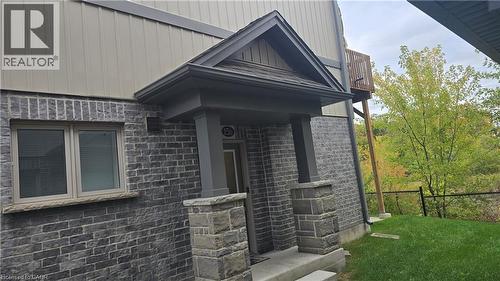 View of exterior entry featuring a porch and board and batten siding - 115 South Creek Drive Unit# 15D, Kitchener, ON - Outdoor With Exterior