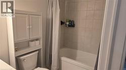 Bathroom with shower / bath combination with curtain and toilet - 