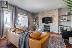 Living area with wood finished floors, a fireplace, built in features, and recessed lighting - 