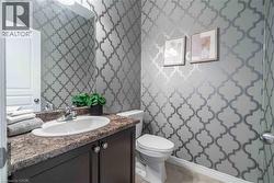 Powder room on main level tucked away next to laundry area. - 