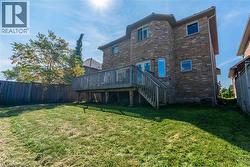 Rear view of house with brick siding, a wooden deck, and stairway - 