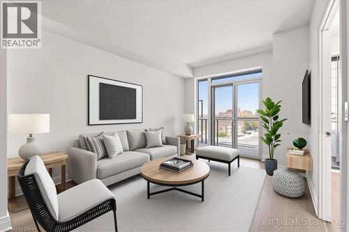 Living room with light wood-style flooring and baseboards - 55 Speers Road Unit# 415, Oakville, ON - Indoor Photo Showing Living Room