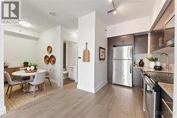 Kitchen featuring stainless steel appliances, light wood-style flooring, modern cabinets, backsplash, and light stone countertops - 