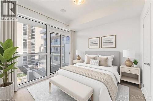 Bedroom with wood finished floors, access to outside, and floor to ceiling windows - 55 Speers Road Unit# 415, Oakville, ON - Indoor Photo Showing Bedroom