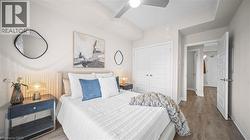 Bedroom with wood finished floors, ceiling fan, and a closet - 