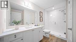Bathroom featuring vanity, a stall shower, and dark wood-style floors - 