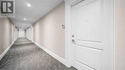 Hall with dark carpet and recessed lighting - 
