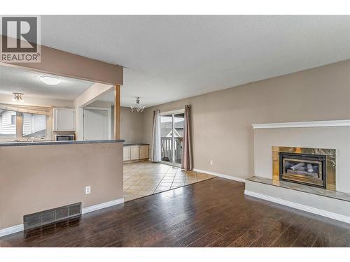 Living Room looking into Dining Room/ Kitchen - 758 Josselyn Court, Kelowna, BC - Indoor Photo Showing Living Room With Fireplace