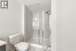 Bathroom with vanity, a stall shower, and light tile patterned floors - 