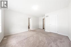 Unfurnished bedroom with light carpet and baseboards - 