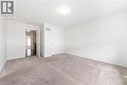Unfurnished bedroom with light carpet and baseboards - 