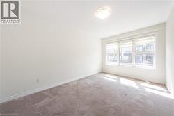 Carpeted spare room featuring baseboards - 