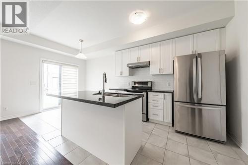 Kitchen with appliances with stainless steel finishes, white cabinetry, pendant lighting, and light tile patterned floors - 391 Athabasca Common, Oakville, ON - Indoor Photo Showing Kitchen With Double Sink With Upgraded Kitchen