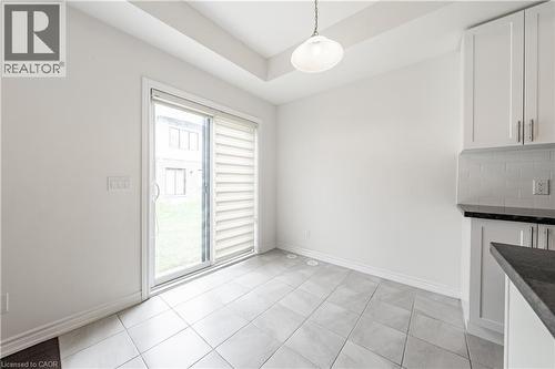 Unfurnished dining area featuring a raised ceiling and light tile patterned floors - 391 Athabasca Common, Oakville, ON - Indoor