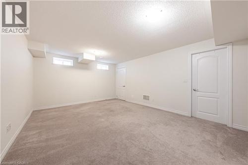 Basement with a textured ceiling and light carpet - 391 Athabasca Common, Oakville, ON - Indoor